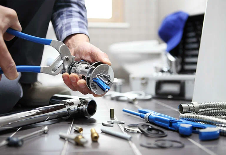 Technician repairing a plumbing fixture with professional tools in Atlanta