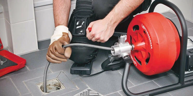 Plumber using a drain-cleaning machine in Atlanta