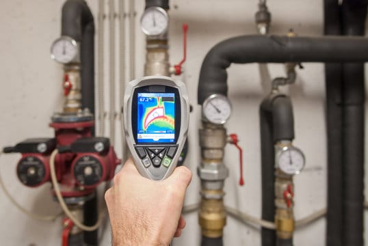 Plumber using a thermal imaging camera to inspect pipes in Atlanta